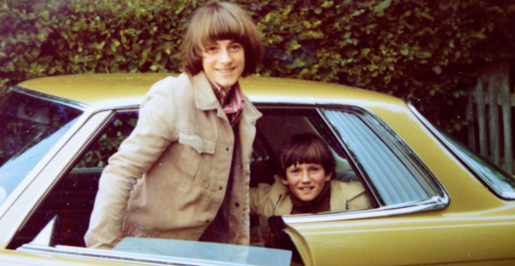 Two boys next to a gold Merecedes SLK in the 1970s.